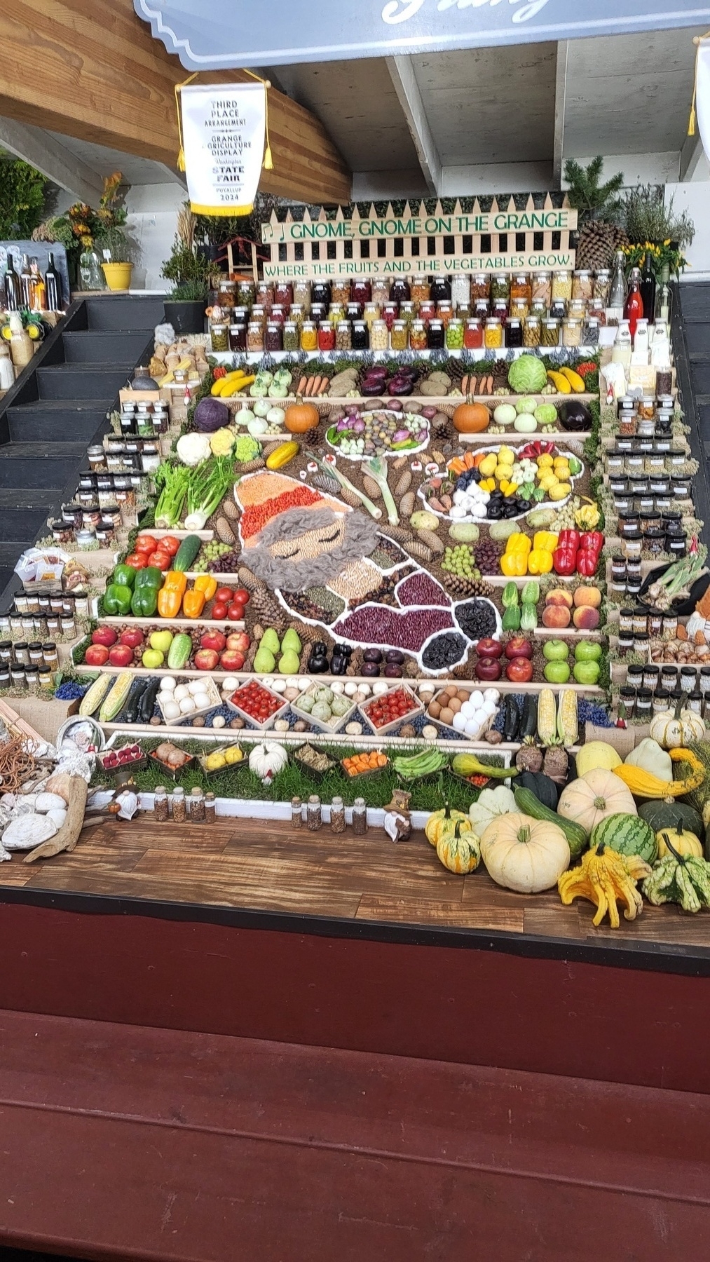 A large display on all kinds of produce and canned goods. They make a mosaic featuring a large gnome.