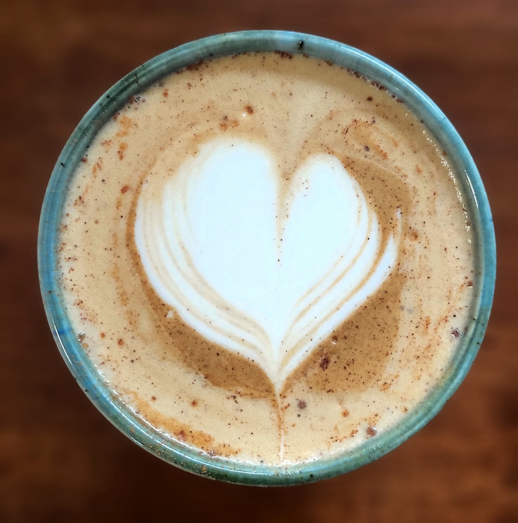 A heart in a cup of coffee with cinnamon.