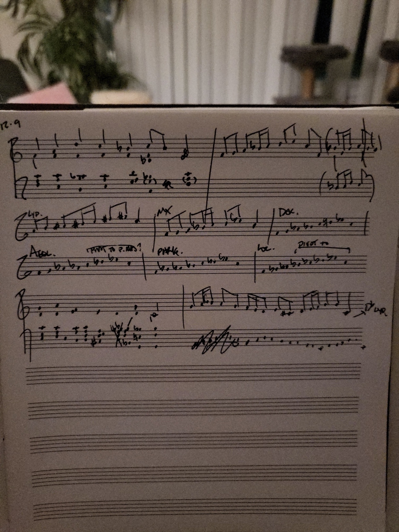 Handwritten music in a notebook. There are some scribbled out bits, alternate gestures, and theoretical workings-out.